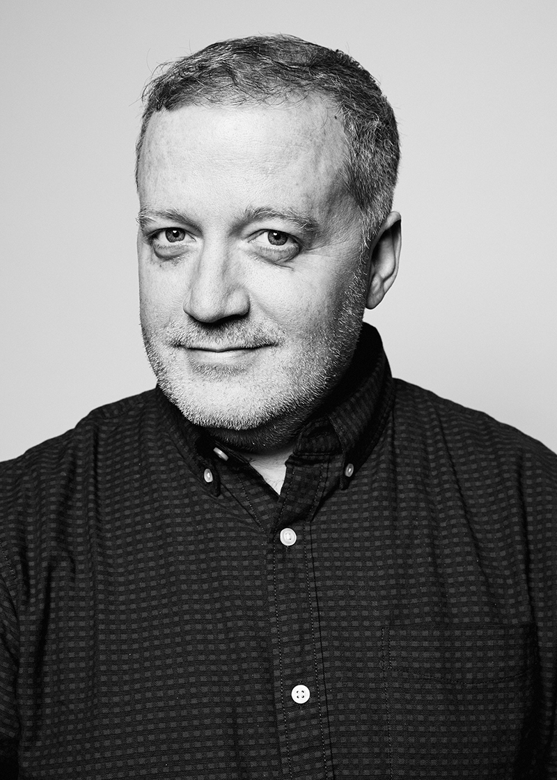 A black and white headshot of a male artist