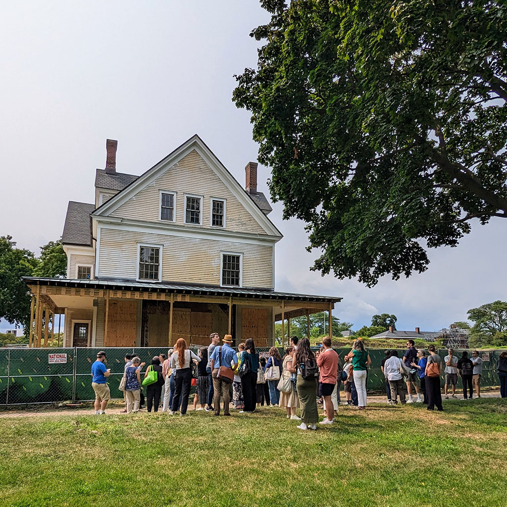 A group of people stands in front of a historic building