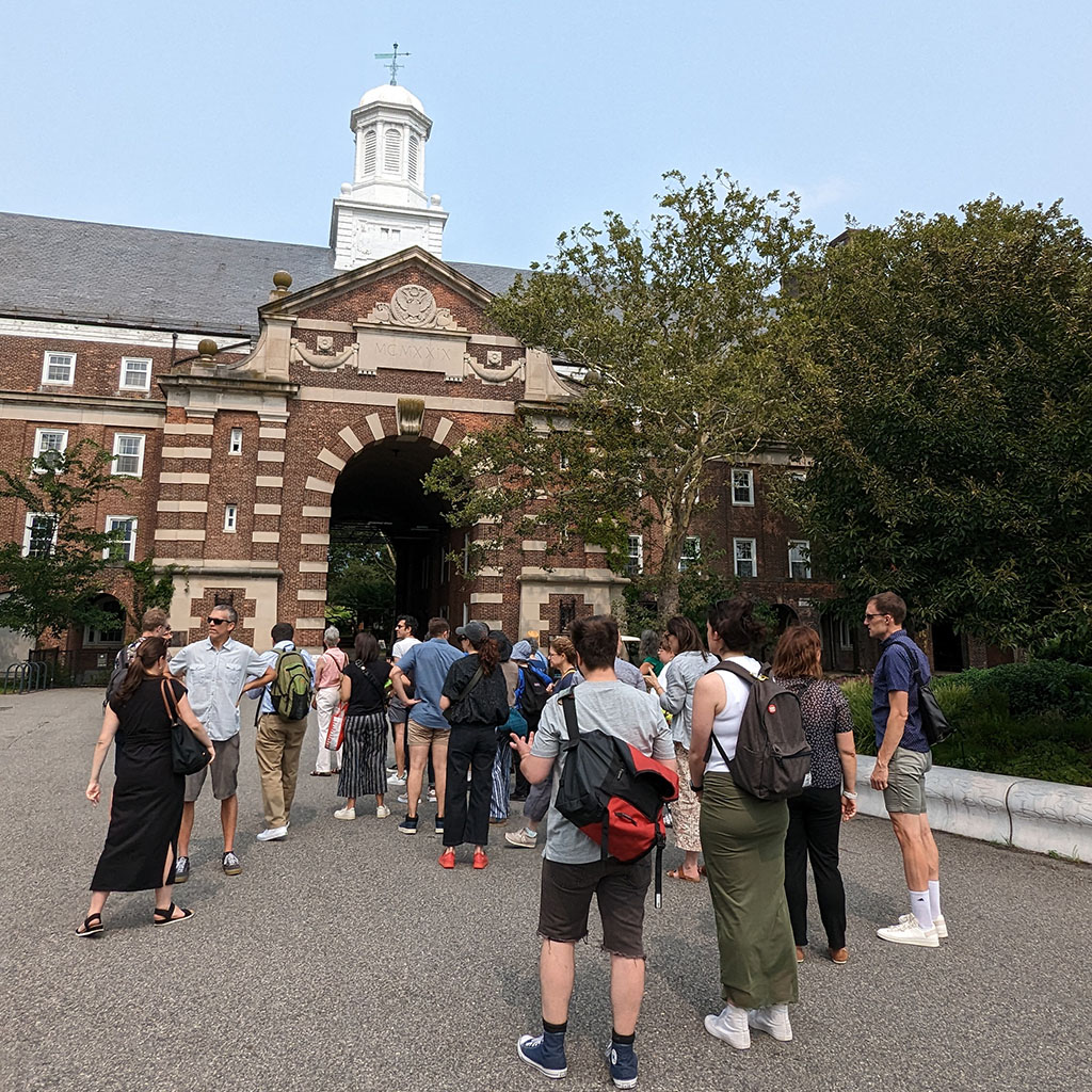 A group of people stands in front of a historic building 