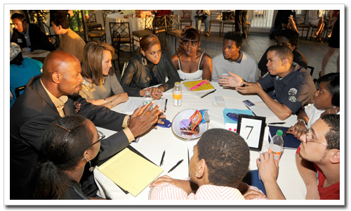 Alonzo Mourning (left) and Alina Cho, CNN correspondent and NYFC Friends Committee Member have the full attention of youth in roundtable discussion.