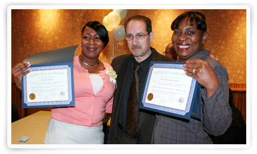 Graduates Shanene Bryant, left, and Dinah Clemmons-Gibson celebrate with Mike Arsham.