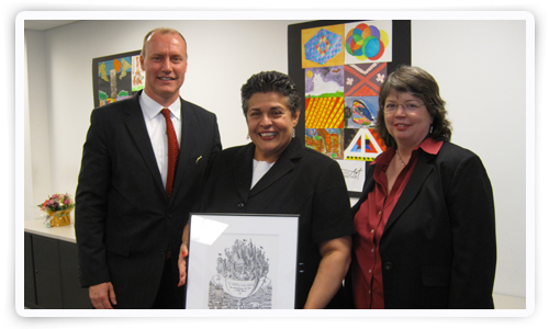 Sonia Galarza with a framed illustration of her Sloan Award with Larry Busching and Belinda Conway.