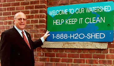 Commissioner Miele displays the new watershed signs.