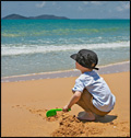 child at beach with sun hat