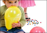 child with balloon near mouth