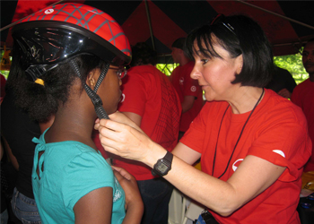 DOT staff teaching young cyclists how to properly fit a helmet