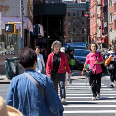 Older adults cross a street following the pedestrian “walk” signal.