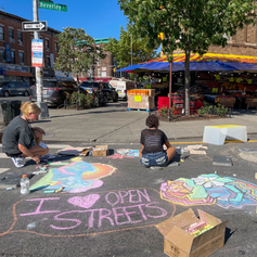 An Open Street decorated with chalk drawings. One of the drawings says I Heart Open Streets