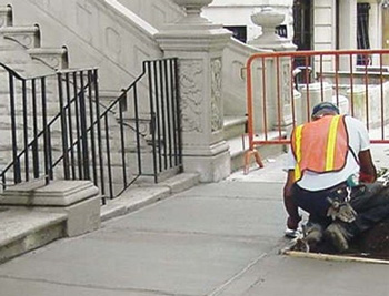 Sidewalk repair man working on sidewalk Sidewalk repair man working on sidewalk