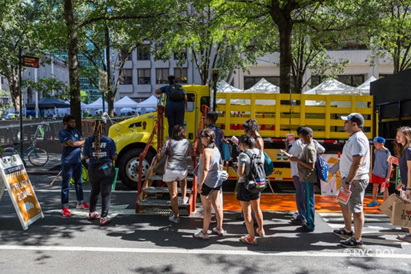 Yellow DOT truck with people standing near