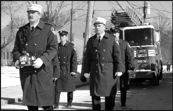 Capt. Ralph Celentani of Engine 290 carries the Ladder 103 helmet during the funeral procession for Firefighter Sclafani to Our Lady Star of the Sea R.C. Church.