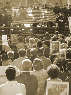 Family members and friends raise photos of their loved ones at the World Trade Center site during the annual memorial on September 11, 2006
