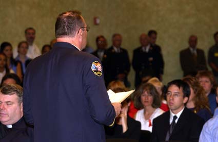 Fire Department Chaplain reading at memorial held at Fire Department Headquarters