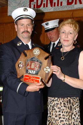 Anne Downing is presented with her late husband's promotion plaque.