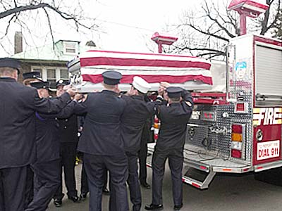 A truck from Ladder Company 61 carrying the coffin of Firefighter and Sgt. Christian Engeldrum 
