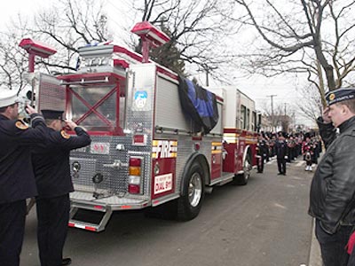 The casket of Army Sgt. and New York City firefighter Christian P. Engeldrum travels on a firetruck after a funeral service