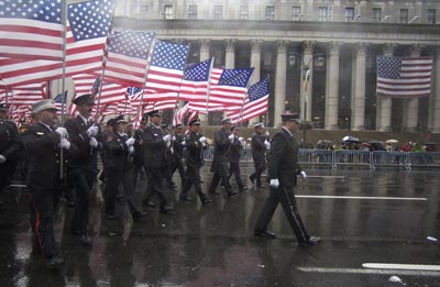 Firefighters carrying American flags march to Madison Square Gardern.