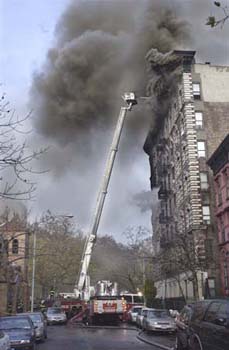 A fire started in a 4th floor apartment of this 7-story brick when a women left a burning cigarette in an ashtray on top of a bed. The comforter eventually caught fire...