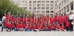 Kids from the New York Emperors Stickball League, honoring fallen Firefighter Steve Mercado (Engine 40), pose with members from the NYPD and the FDNY stickball teams.