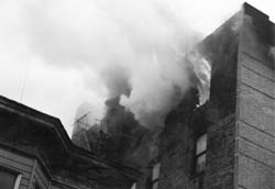FF Robert McGrath dons his mask prior to making entry into well-involved apartment.