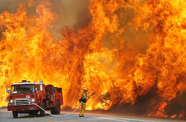 Photo: A California Department of Forestry firefighter is dwarfed by flames along East Grade Road on Palomar Mountain. Photo courtesy of Wally Skalij / Los Angeles Times. October 24, 2007