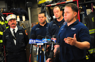 Firefighter Mike Czech describes how he helped rescue a mother and her two sons from the fire as (L to R) Deputy Chief Paul Ferro, Firefighter Doug Caffarone and Firefighter Edward Rissland look on.
