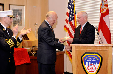 Fire Commissioner Nicholas Scoppetta accepts a check for $175,000 from Chairman of the New York Fire Safety Foundation Dr. Gerry Lynch.