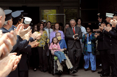 Lt. Martin Fullam is cheered by firefighters from across the city as he leaves New York Presbyterian Hospital-Columbia University Medical Center with his family.