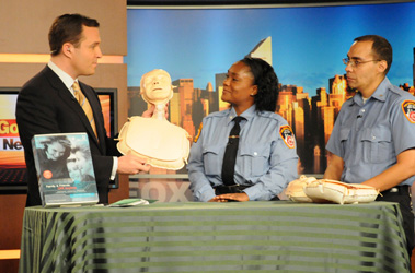 EMTs Pablo Vazquez and Keira Betty teach CPR to Fox 5's Greg Kelly.