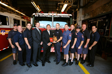 Firefighter Adam Rivera (center with award) receives the Liberty Mutual Firemark Award from Sales Representative Kenneth McQuillen (fourth from left) and Branch Manager Damion Del Corsano (fifth from left). They are joined by the members of Engine 10/Ladder 10 in Lower Manhattan.