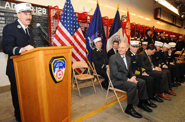Capt. James Mills of L-128 addresses the crowd at his company's centennial as Fire Commissioner Salvatore Cassano, Chief of Department Edward Kilduff and other officials look on.