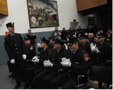 Firefighter Jeffrey Callaghan stands to be recognized for his military service during the ceremony. He will be deployed with the U.S. Navy soon.