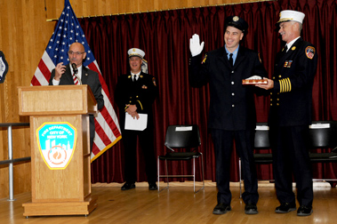 Fire Commissioner Salvatore Cassano and Chief of Department Edward Kilduff promote the 15 members at the Fire Academy.