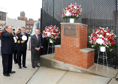 Monsignor John Delendick blesses the plaque as Fire Commissioner Salvatore Cassano and Chief of Department Edward Kilduff.