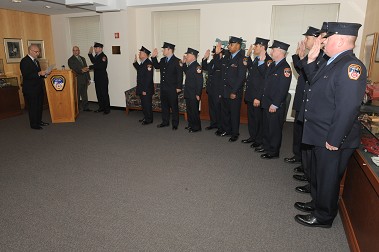 Chief Fire Marshal Robert Byrnes holds the Bible as Fire Commissioner Salvatore Cassano leads the new fire marshals in the Oath of Office.