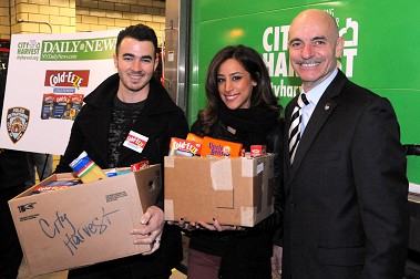 Fire Commissioner Salvatore Cassano with Kevin and Danielle Jonas, who helped collect food for City Harvest's annual drive. Fans got to take photos with the couple if they donated food for the cause.