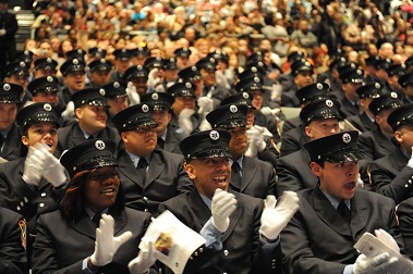 The new graduates cheer as their classmates receive their diplomas.