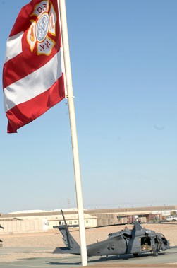 The FDNY flag flying above their camp, with the team's helicopter in the background. Nine FDNY firefighters were deployed together as part of the 26th Expeditionary Rescue Squadron. Photo courtesy of Air Force Master Sgt. James Martin.