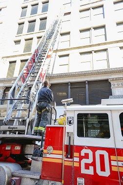 Firefighters from Ladder 20 extend their ladder to the eighth floor, as far as their apparatus could reach at that time, to remember the victims.