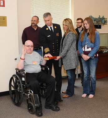 Cooper Anderson takes the Oath of Office. Chief of Department Edward Kilduff and Cooper's mother, Myra, hold the Bible