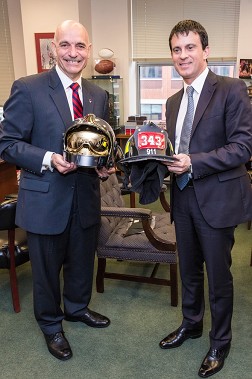 Fire Commissioner Salvatore Cassano (left) and French Minister of the Interior Manuel Valls exchange helmets.