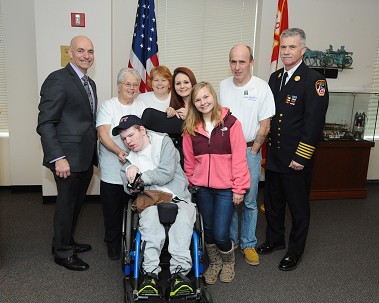 Fire Commissioner Salvatore Cassano and Chief of Department Edward Kilduff with Honorary Firefighter Seth Kelly and his mother and step-father, Kathy and Jeff Bird, his sisters, Cassandra and Kate Kelly, and his grandmother, Patricia Bates.