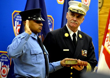 Chief of Department Edward Kilduff stands with Probationary Firefighter Raheem Hassan as he takes the Oath of Office.