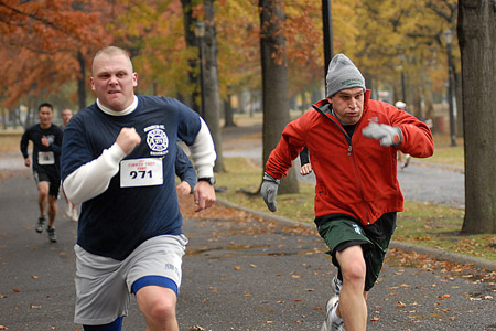 Runners head towards the finish line in the 29th Annual Turkey Trot 5K Run as family and friends cheer them on.
