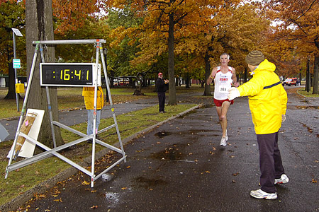 Runners head towards the finish line in the 29th Annual Turkey Trot 5K Run as family and friends cheer them on.