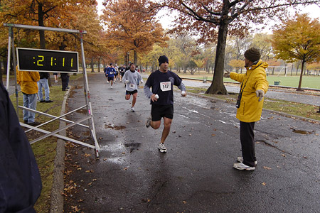 Runners head towards the finish line in the 29th Annual Turkey Trot 5K Run as family and friends cheer them on.