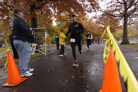Runners head towards the finish line in the 29th Annual Turkey Trot 5K Run as family and friends cheer them on.