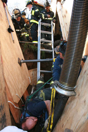 Firefighters use ConEd's vacuum to remove dirt that buried a construction worker to his chest. Photo courtesy of FF David Raynor, Rescue Battalion