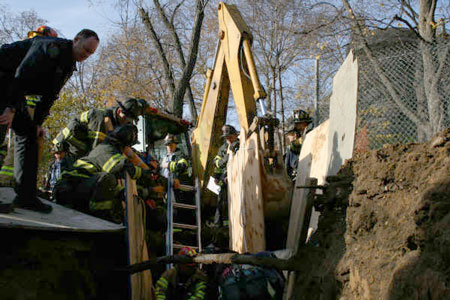 As firefighters worked to remove a construction worker from a trench collapse in upper Manhattan, HazTac paramedics helped stablize the patient and administered an intravenous line to help relieve his pain. Photo courtesy of FF David Raynor, Rescue Battalion