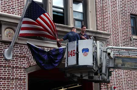 Firefighters at Ladder 146 hang bunting in honor of Firefighter Daniel F. Pujdak at their quarters in Brooklyn on June 22. Photo courtesy of Photographer Michael Schwartz, New York Daily News.